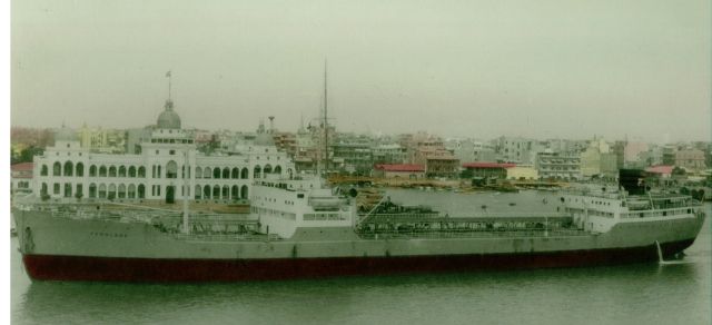 Fermland passerar Port Said på väg in i Suezkanalen. Ett kolorerat fotografi, ett vanligt fotoställe.